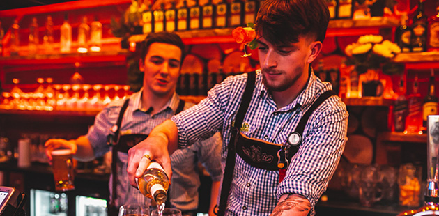 Bartender in German bar UK nightclubs pouring drinks